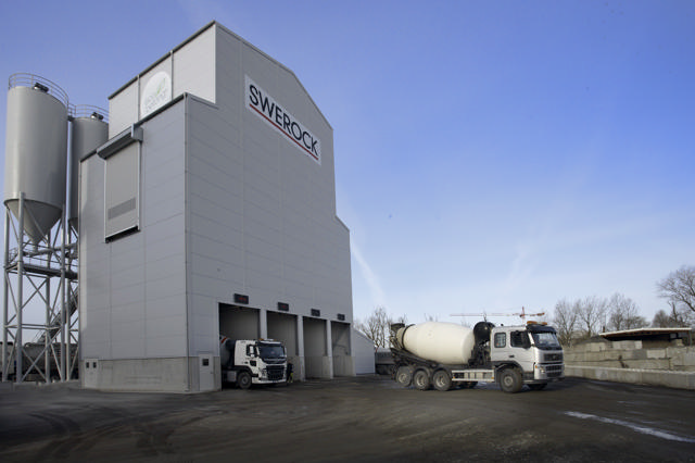 Betonwerk mit 2 Lastkraftwagen, die angekommen sind, um Beton abzuholen.